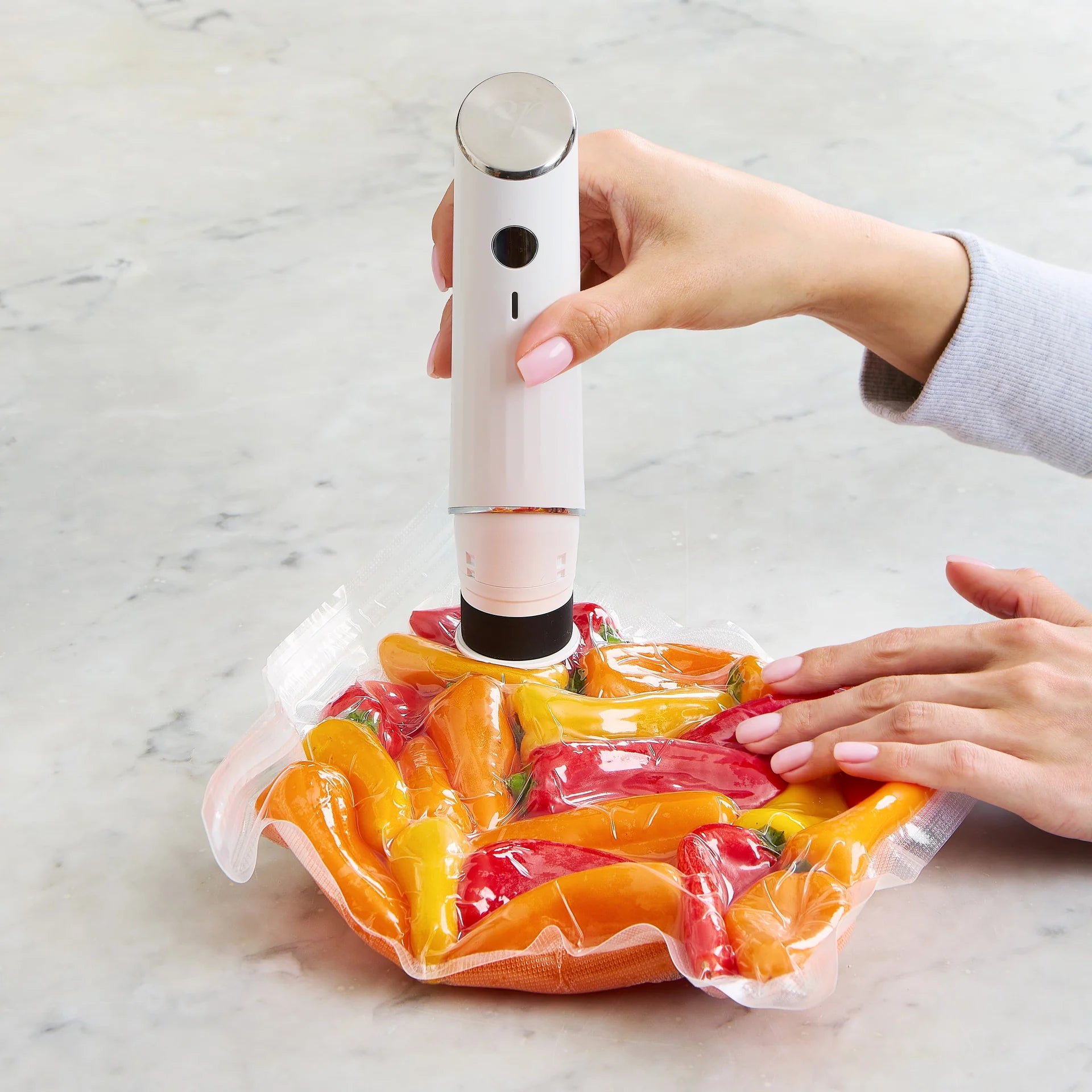 Chef Preserve compact vacuum sealer used to seal assorted fruits and cheese slices in kitchen