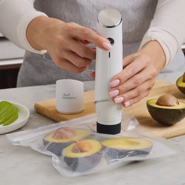 Chef Preserve compact vacuum sealer sealing sliced avocados in airtight bag on kitchen counter